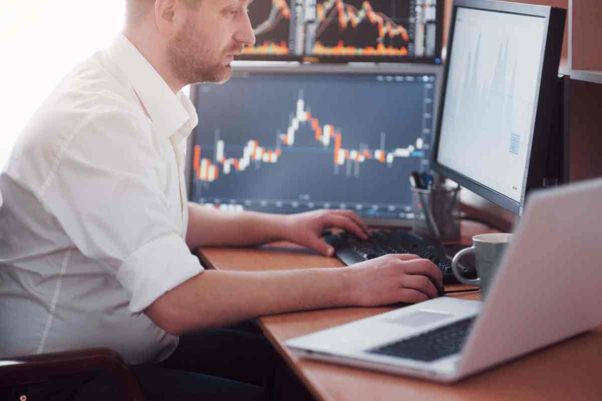 Busy working day. Close-up of young businessman looking at monitor while sitting at the desk in creative office Achievable FINRA course content updated for new SEC T+1 settlement rules